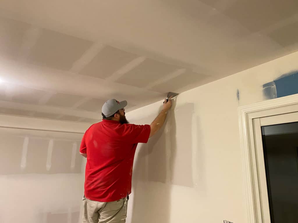 person applying spackle to interior ceiling
